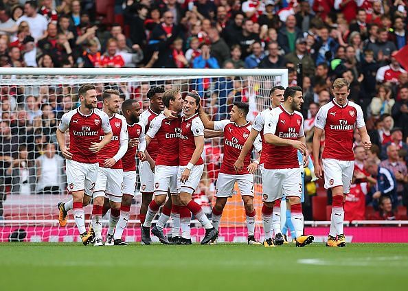 Arsenal players celebrate scoring against Brighton