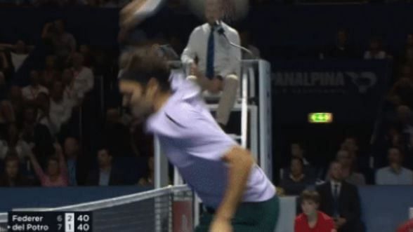 Federer smashes his racquet into the net