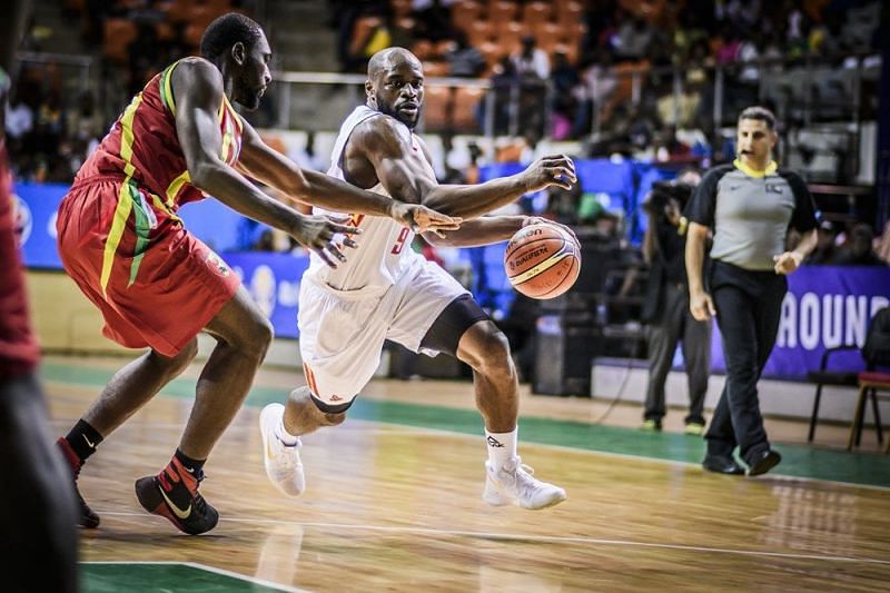 Cameroon&#039;s Jeremy Nzeulie (9) drives the ball to the basket against a Guinea defender.