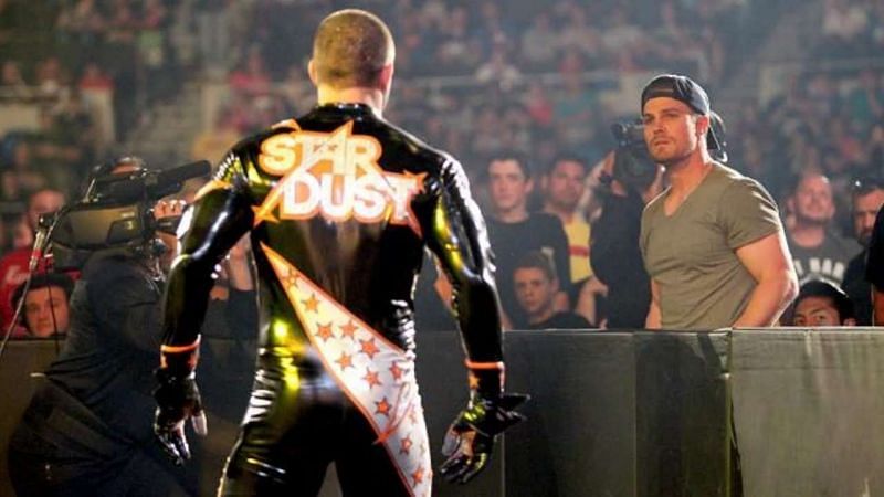 Stephen Amell facing off against Cody Rhodes (then Stardust) in a WWE arena