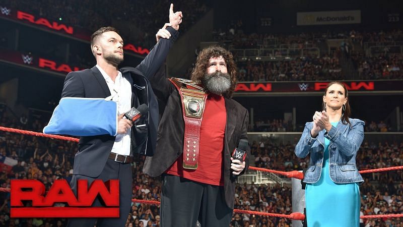 Finn Balor in the ring with Mick Foley and Stepanie McMahon 