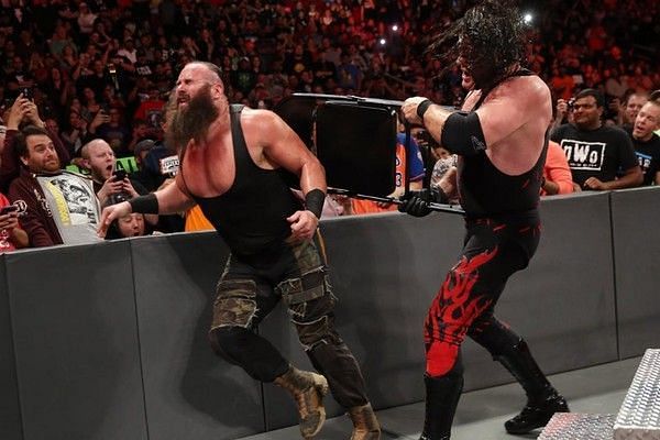 Kane hits Braun Strowman with a chair.