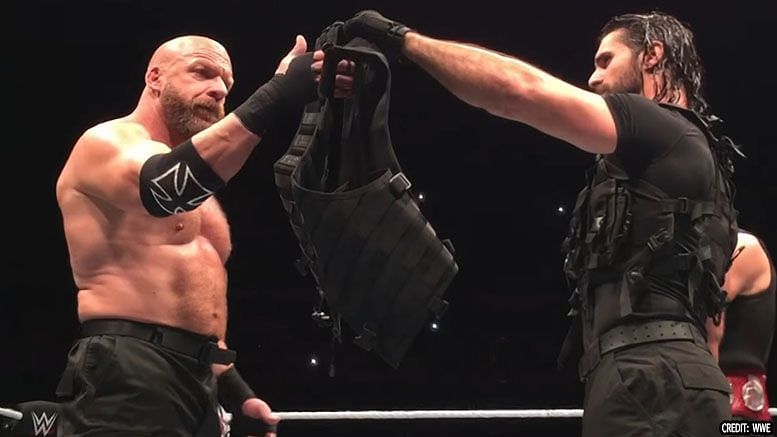 Seth Rollins handing over The Shield vest to Triple H in Glasgow