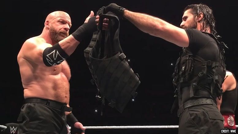 Seth Rollins handing over The Shield vest to Triple H in Glasgow