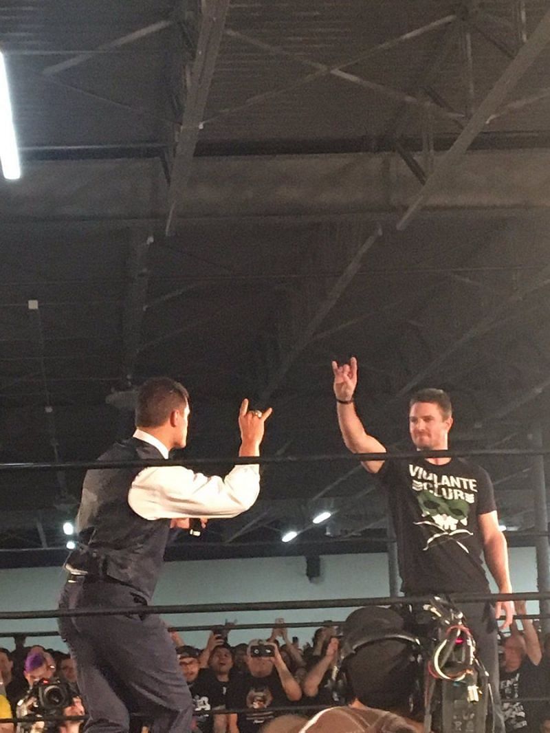 Stephen Amell doing the Too Sweet gesture with Cody Rhodes
