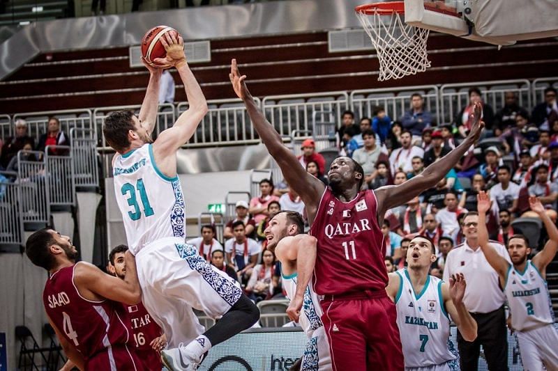 Kazakhstan&#039;s Anatoliy Kolesnikov (31) shoots a jump shot over the Qatar defender.