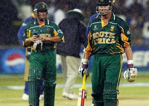 Lance Klusener and team-mate Mark Boucher of South Africa leave the field as rain falls