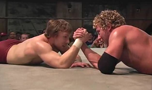 A young Daniel Bryan and Kenny Omega arm wrestle