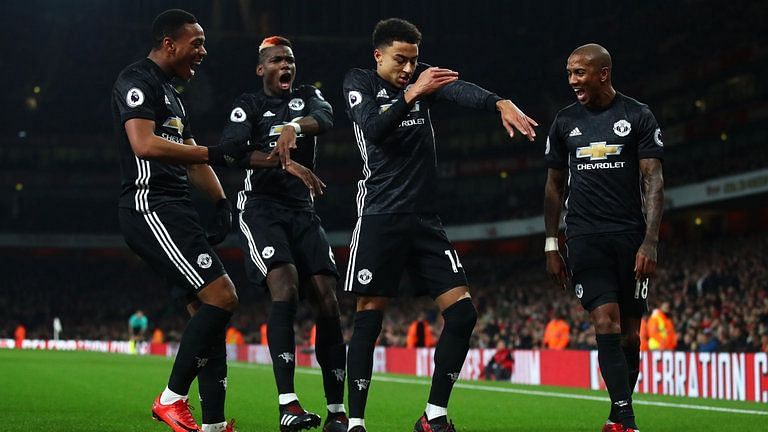 Manchester United players celebrate after scoring against Arsenal