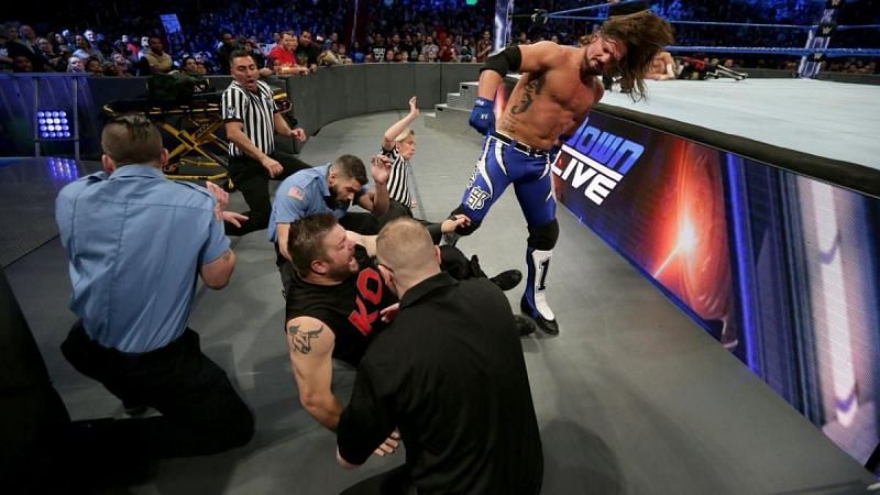 AJ Styles attacks an injured Kevin Owens