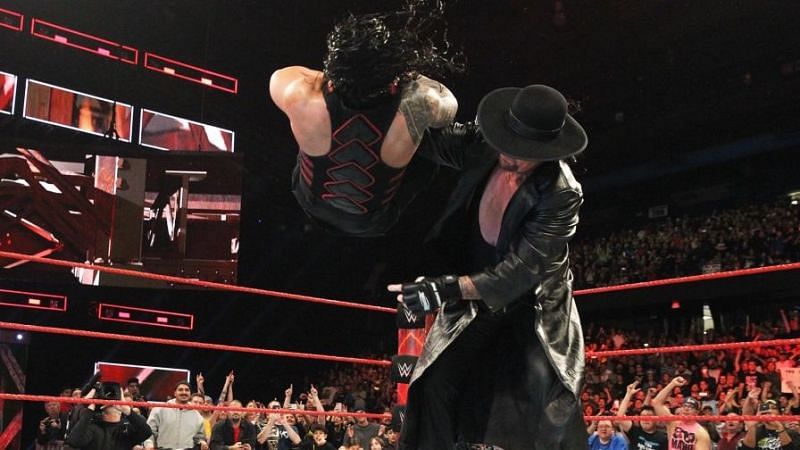 Undertaker delivering a chokeslam to Roman Reigns
