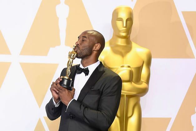 Kobe Bryant kisses his Oscar trophy.