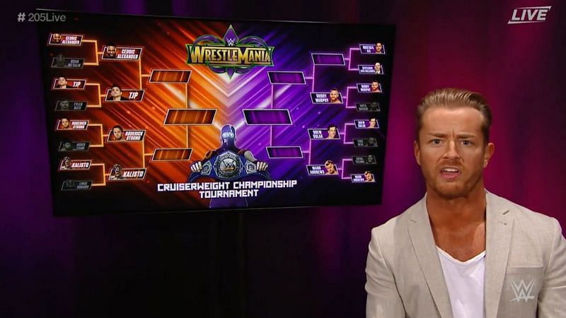 205 Live GM Drake Maverick standing with the Cruiserweight tournament bracket