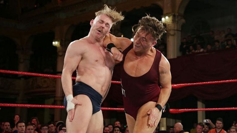 Pete Dunne rocks Tyler Bate with a stiff forearm smash.