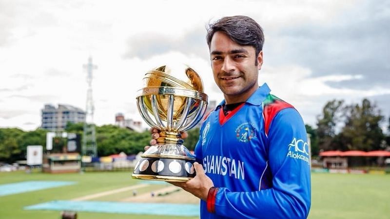 Rashid Khan posing with the ICC World Cup Qualifiers winners' trophy