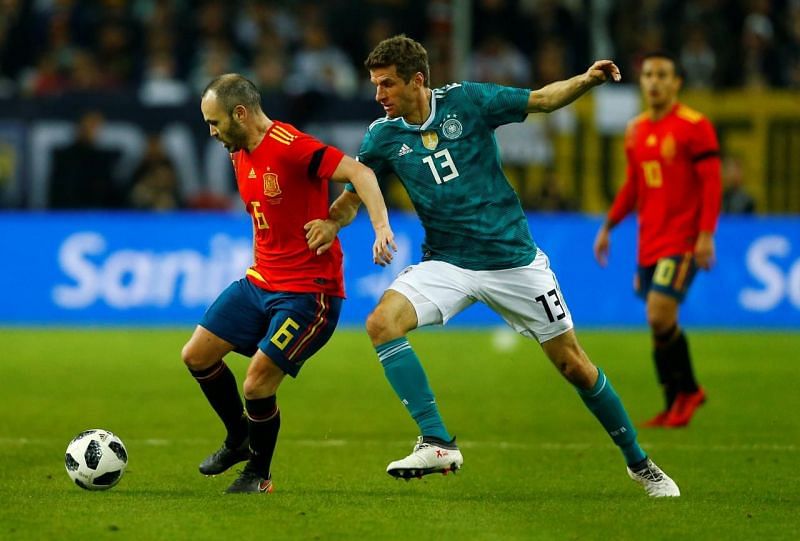 Thomas Muller competing against Andres Iniesta in friendly