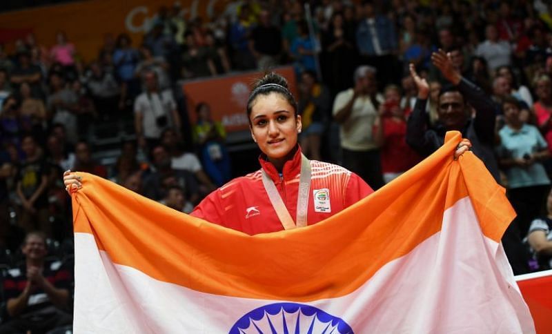 Manika holding the tricolour after winning Gold at the final TT event.