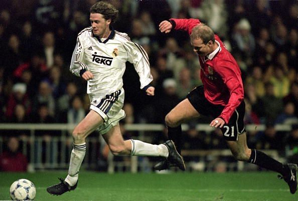 Steve McManaman of Real Madrid is chased by Henning Berg of Manchester United