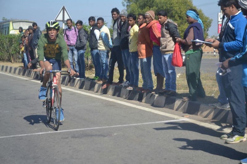 People look on as Abhishek approaches the finish line during one his races