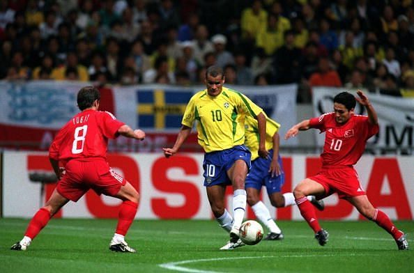 Football. 2002 FIFA World Cup Semi Final. Saitama, Japan. 26th June 2002. Brazil 1 v Turkey 0. Brazil&#039;s Rivaldo is faced by Turkey&#039;s Tugay Kerimoglu (8) as Yildiray Basturk (right) comes in to challenge.Credit: POPPERFOTO/JOHN McDERMOTT