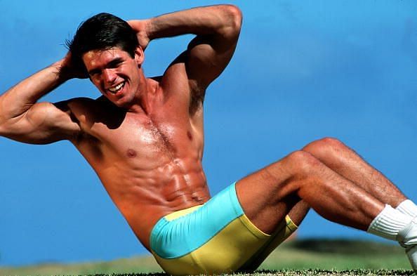 Volume 2, Page 30, picture 8, Sport, Fitness Training, A muscular man does abdominal stretches in lycra shorts