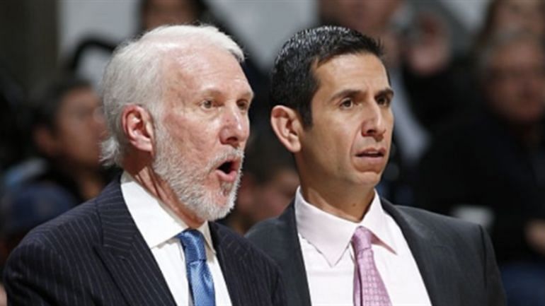 Borrego standing beside Popovich by the bench 