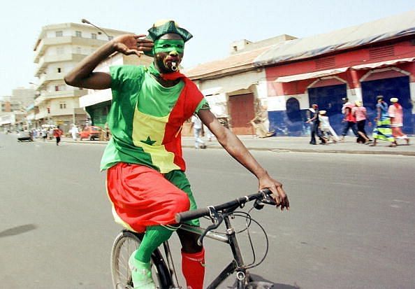 An elated Senegalese soccer supporter rides his bi