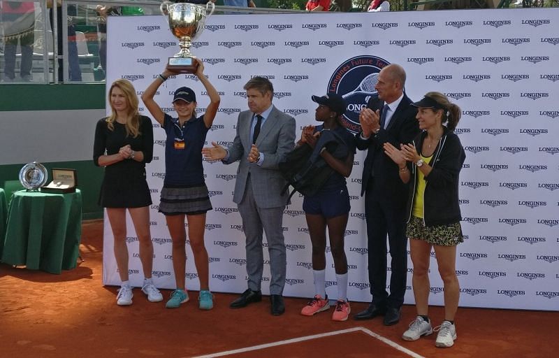 Victoria Jimenez holding her trophy aloft while Steffi Graf (extreme left) and Arantxa Sanchez-Vicario (extreme right) look on