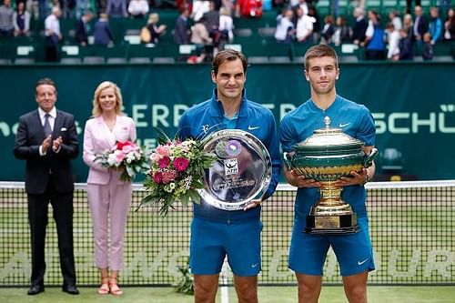 Roger Federer and Borna Coric pose with their plate and trophy, respectively at the Gerry Weber Open 2018.