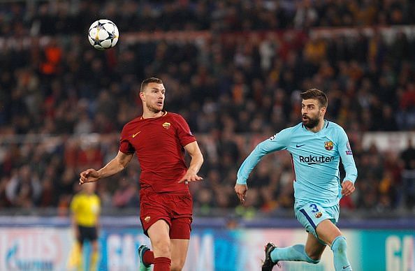 Roma s Edin Dzeko, left, is chased by FC Barcelona Gerard...