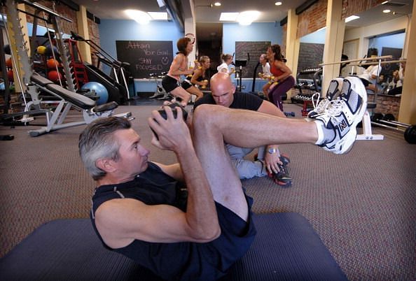 DENVER, COLORADO, JUNE 13, 2006-- John Hutchens &lt;cq&gt; carries a dumbell while working on stomach crunches while trainer Dan Demuth &lt;cq&gt; watches at Malena Marquez&#039;s Body Mecca Concepts boutique gym located at 1231 Elati St. in Denver. (DENVER POST STAFF PHO