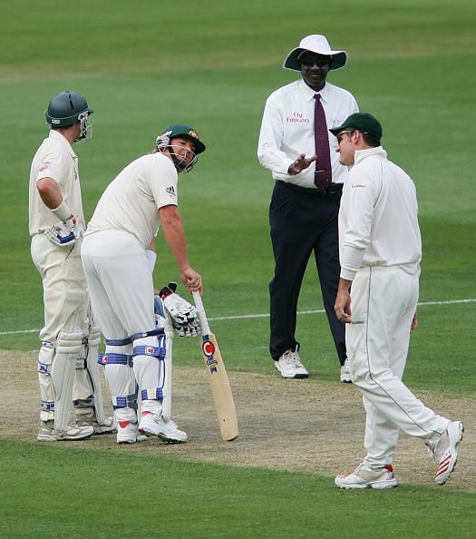 Umpire Steve Bucknor attempts to calm down an exchange between Shane Warne and