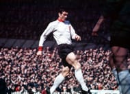 Liverpool's defender Ron Yeats in action, seen through the net.