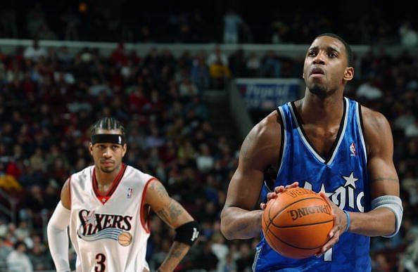 Tracy McGrady shoots as Iverson looks on