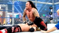 Undertaker delivering a Tombstone piledrive to Edge.