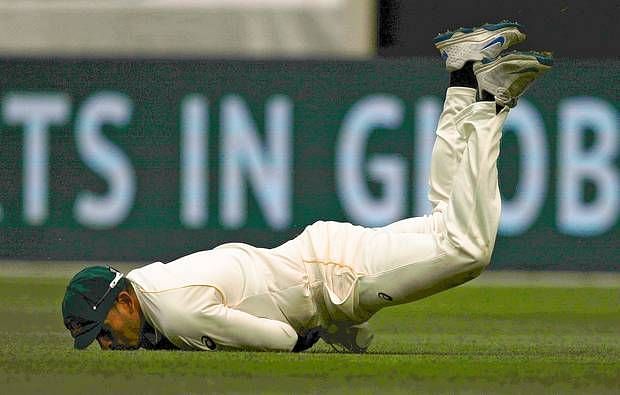  Usman Khawaja dives to take a catch to dismiss Stuart Broad during the Ashes