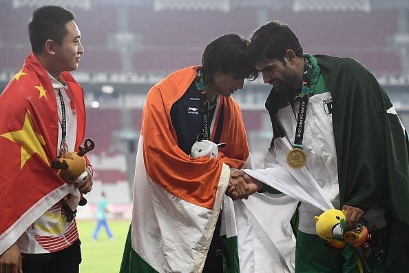 Gold medallist India&#039;s Neeraj Chopra shakes hands with bronze medallist Pakistan&#039;s Arshad Nadeem during the victory ceremony for the men&#039;s javelin throw athletics event during the 2018 Asian Games