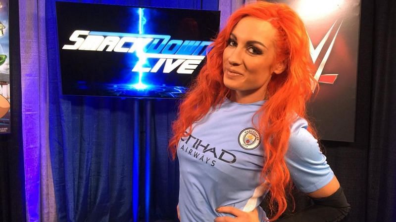 Becky Lynch wearing Manchester City&#039;s jersey.