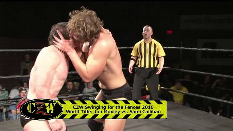 Callihan still swings bats on eyes. Moxley now throws hot dogs on villains