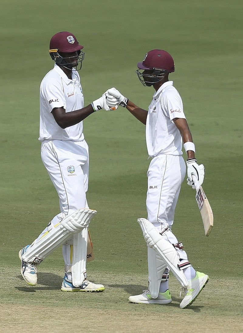 Chase and Holder congratulating each other after a century partnership