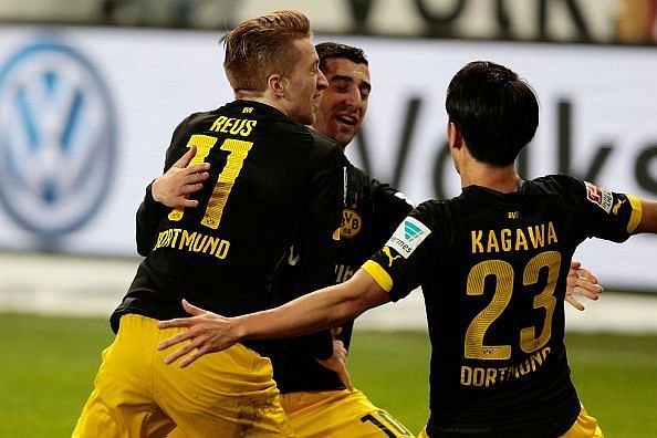Dortmund players celebrate a goal in the match against Wolfsburg in the Bundesliga