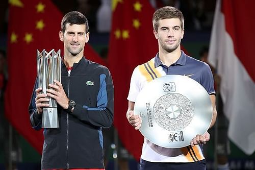 Djokovic holding the winner's trophy and Borna Coric with an unexpected runner-up trophy.