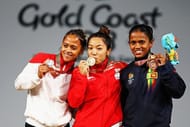 Mirabai Chanu (centre) celebrates on the podium at the Commonwealth Games 2018