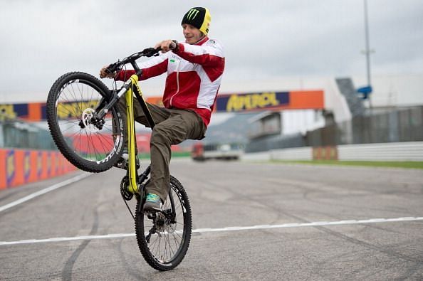 Valentino Rossi pulling off a wheelie with his bicycle at the MotoGP of San Marino