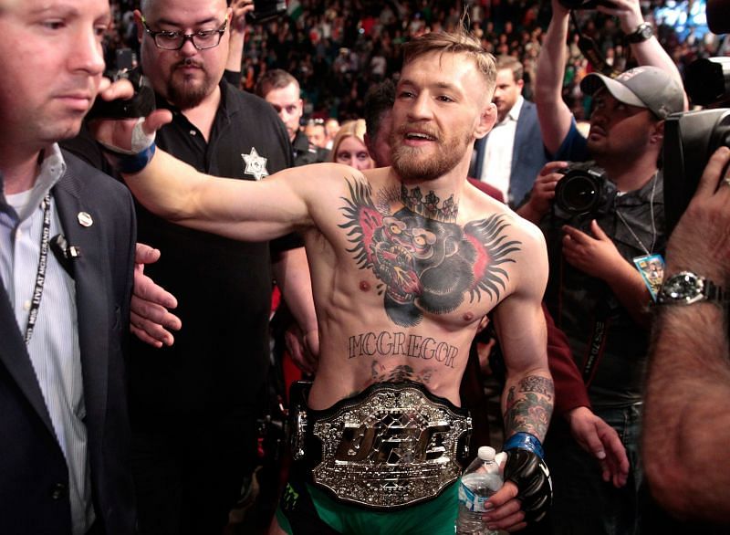 Conor McGregor walks out of the Octagon as the new Featherweight Champion