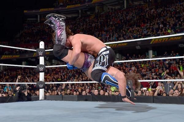 AJ Styles drives his opponent into the mat with the Styles Clash.
