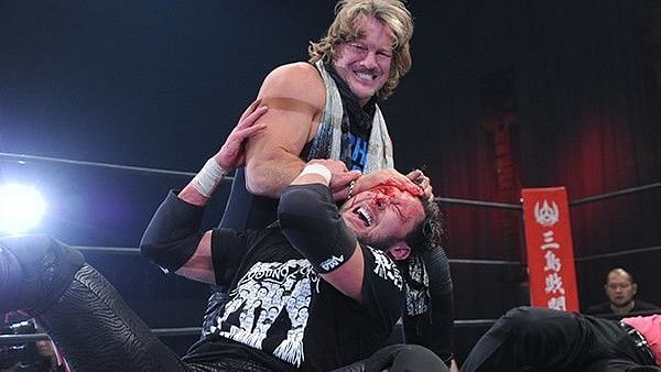 Chris Jericho attacks a bloodied Kenny Omega.