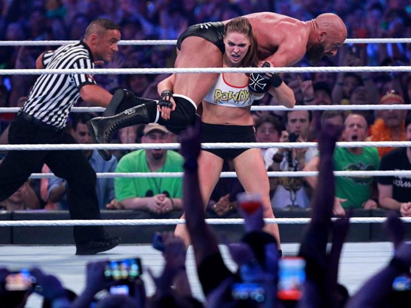The Baddest Women on the Plant lifting up The Game at Wrestlemania 34.