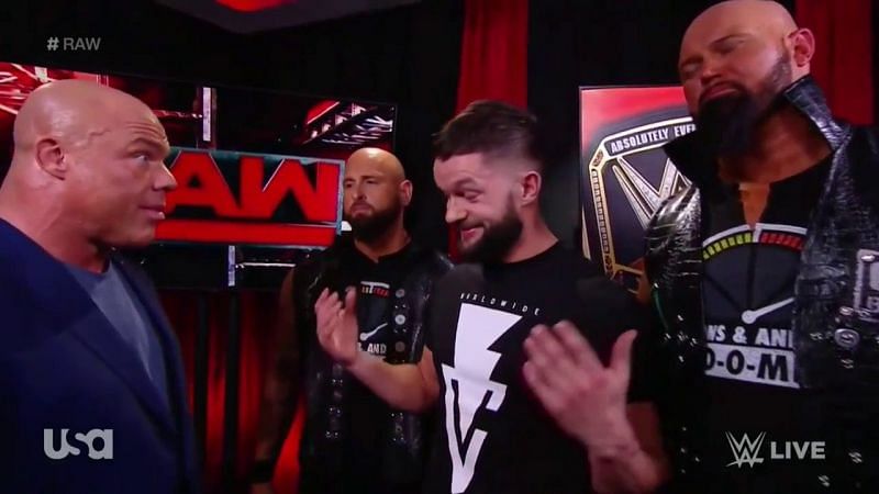Kurt Angle confronts a cocky Finn Balor, flanked by a grim set of Karl Andersen and Luke Gallows.