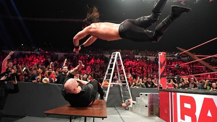 Rollins taking down Corbin with a Crossbody through the table!